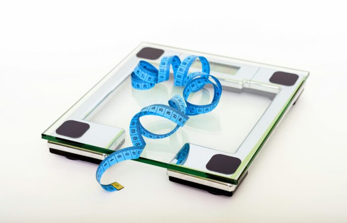 This picture features a weighing scale and a tape measure