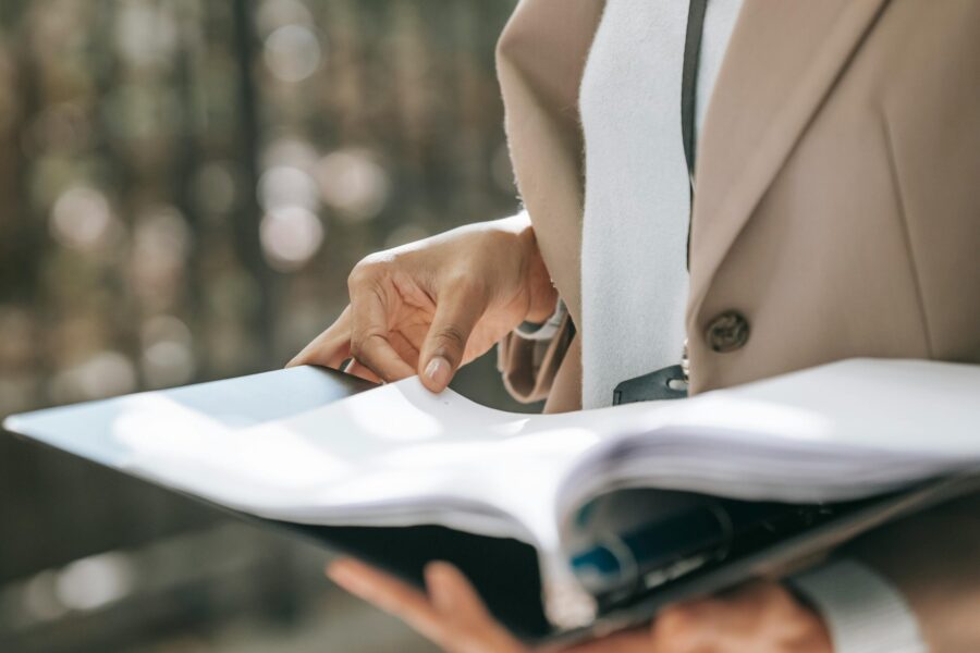 Picture shows someone holding a folder and reading a lengthy document