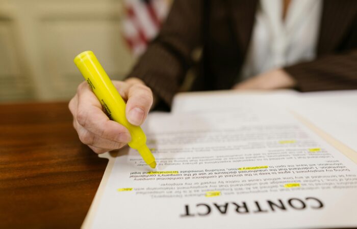 This picture shows the image of someone highlighing words within a contract document